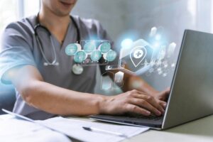 A healthcare professional using a laptop with futuristic digital medical icons and graphics overlaying the image.